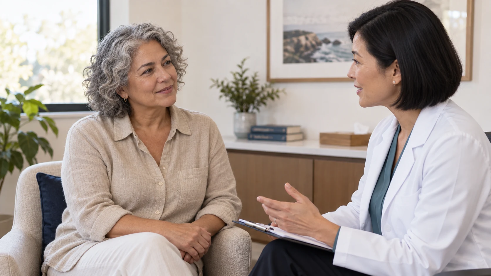 A woman discussing her health with a female clinician in a consultation room.